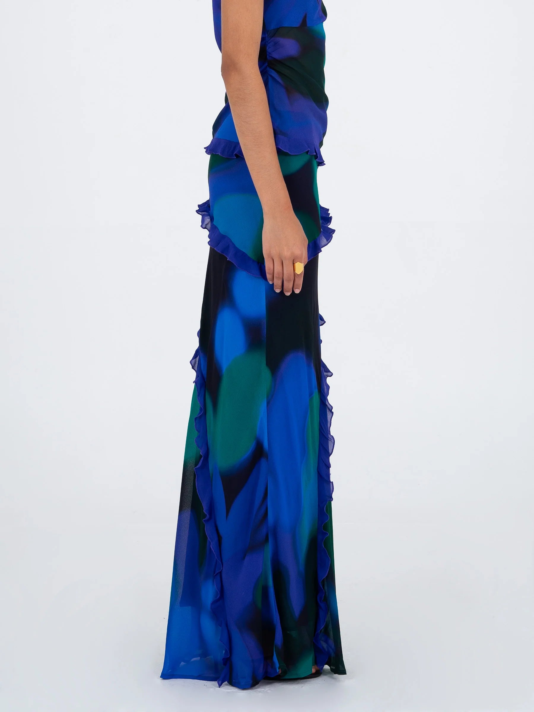 Blue multicolor printed long skirt side view highlighting knee length slit and ruffle trim