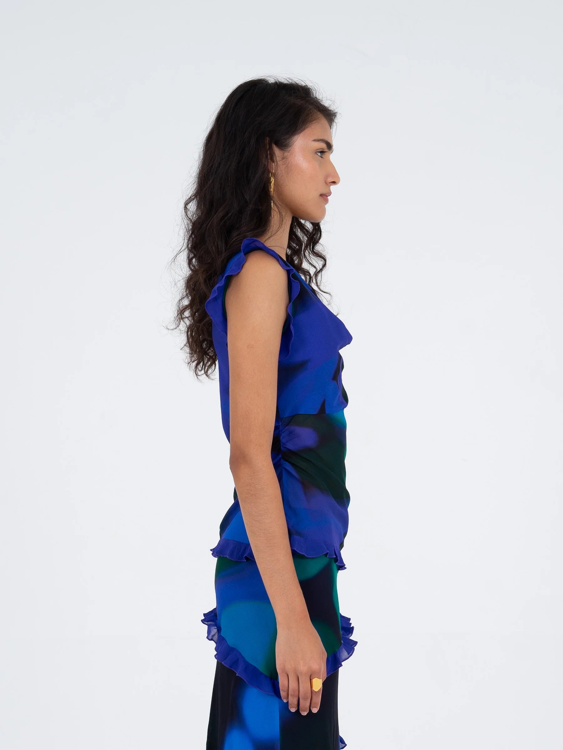 Blue multicolor printed sleeveless blouse side view highlighting side slit and ruffle details