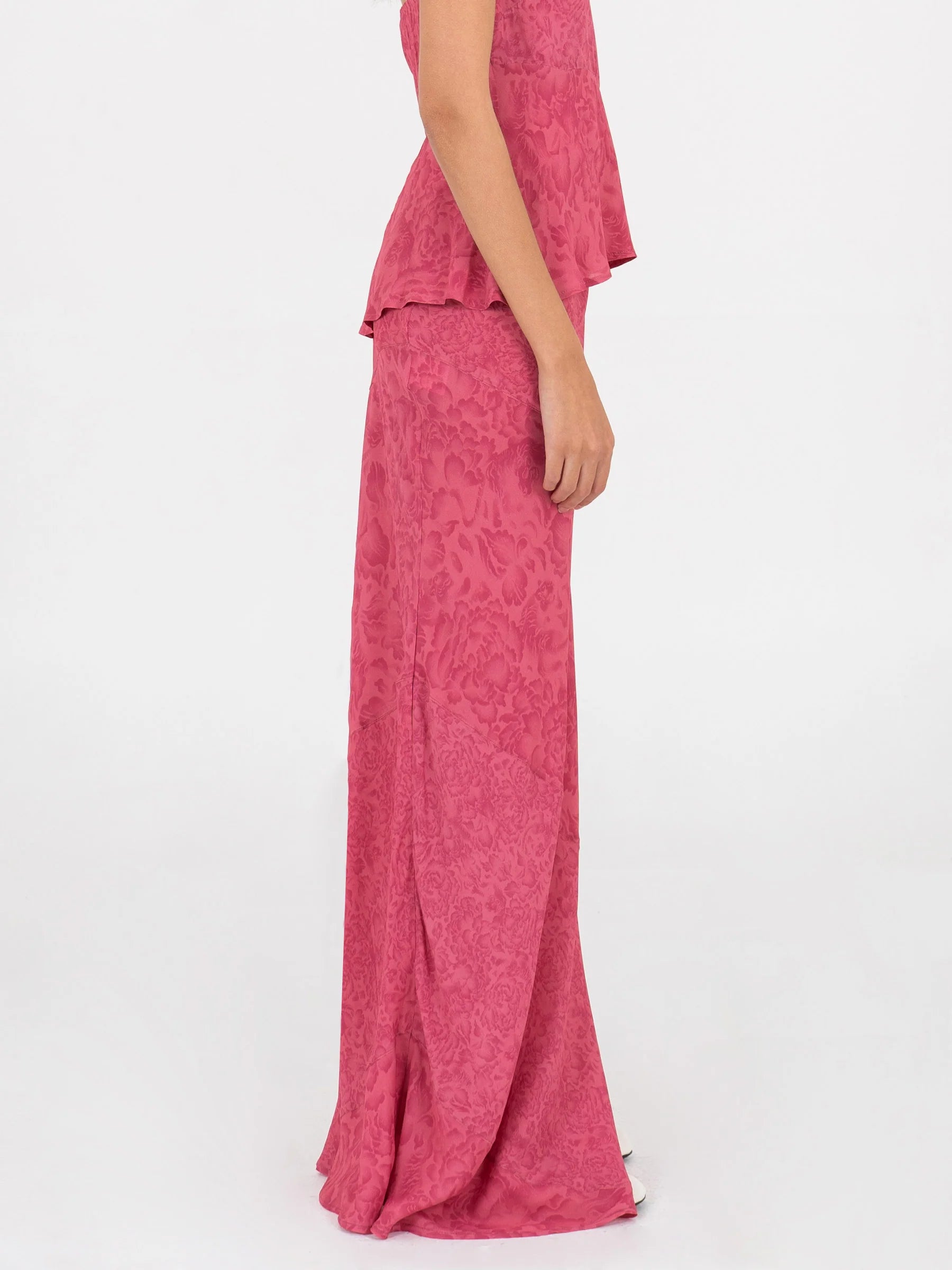 Pink long low rise skirt side view highlighting invisible side zipper clean fitted waistline and fluid silhouette