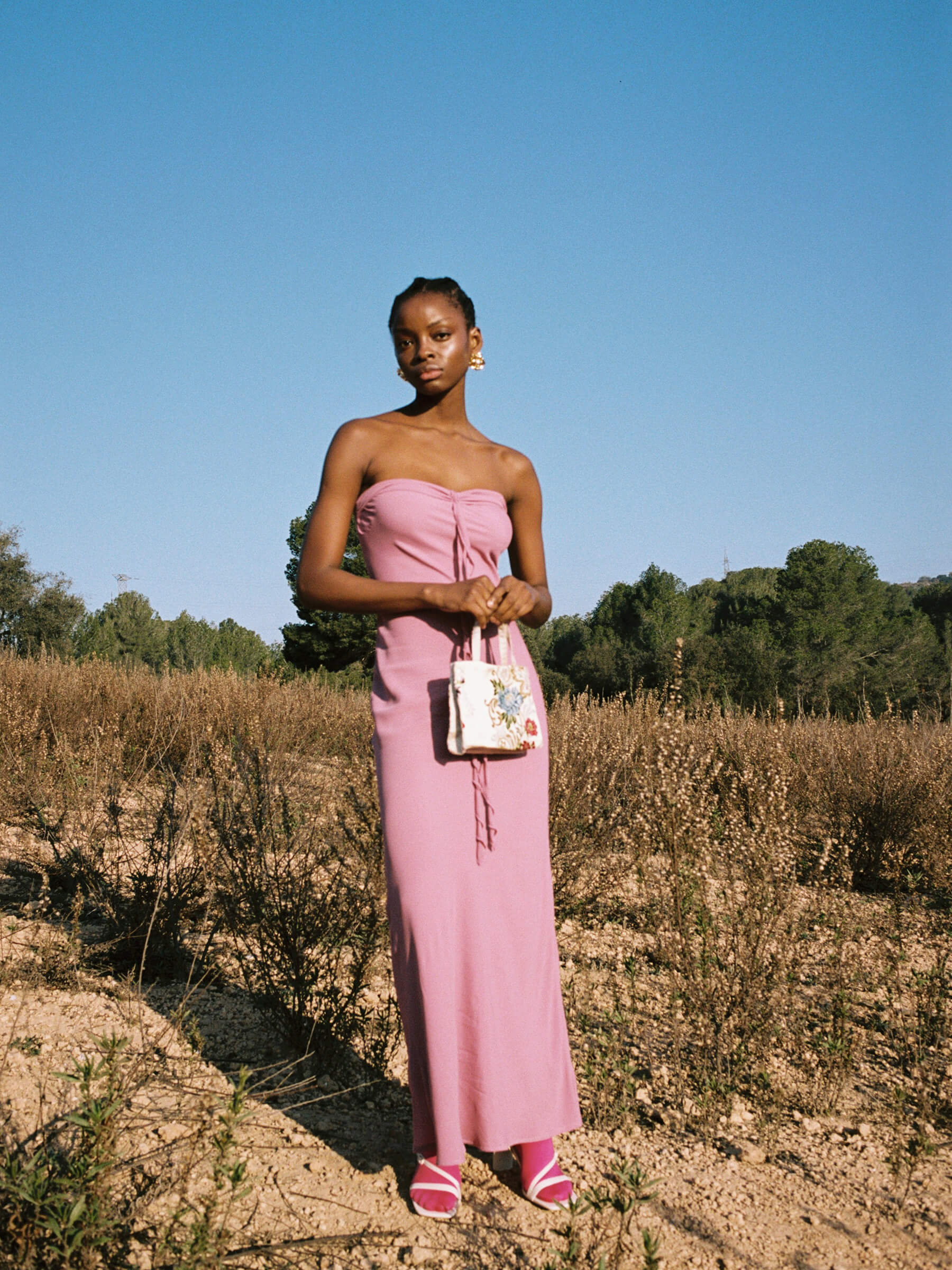 Pink strapless maxi dress outdoor full body look with ruffled strips across chest