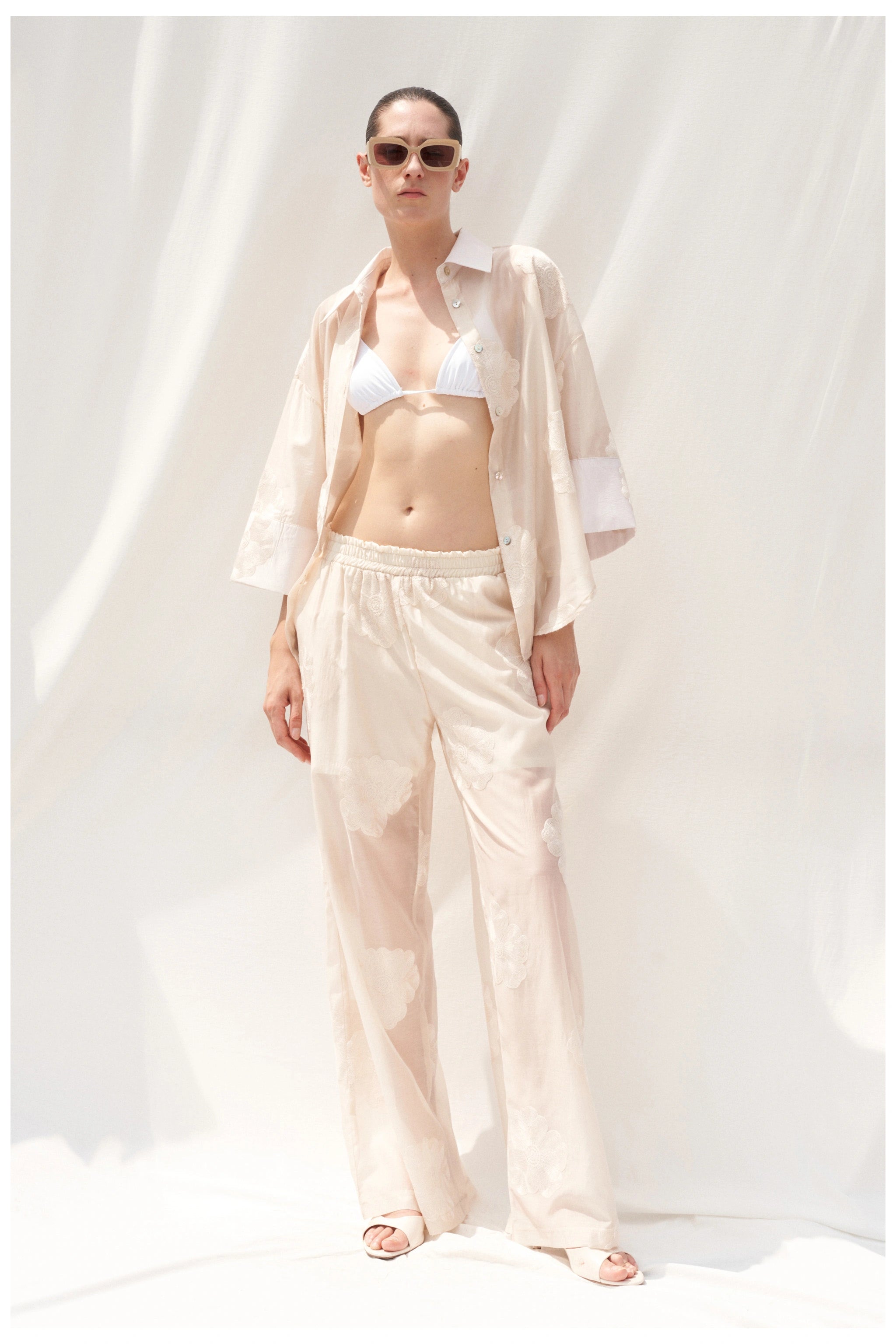 Beige embroidered trousers full length front view